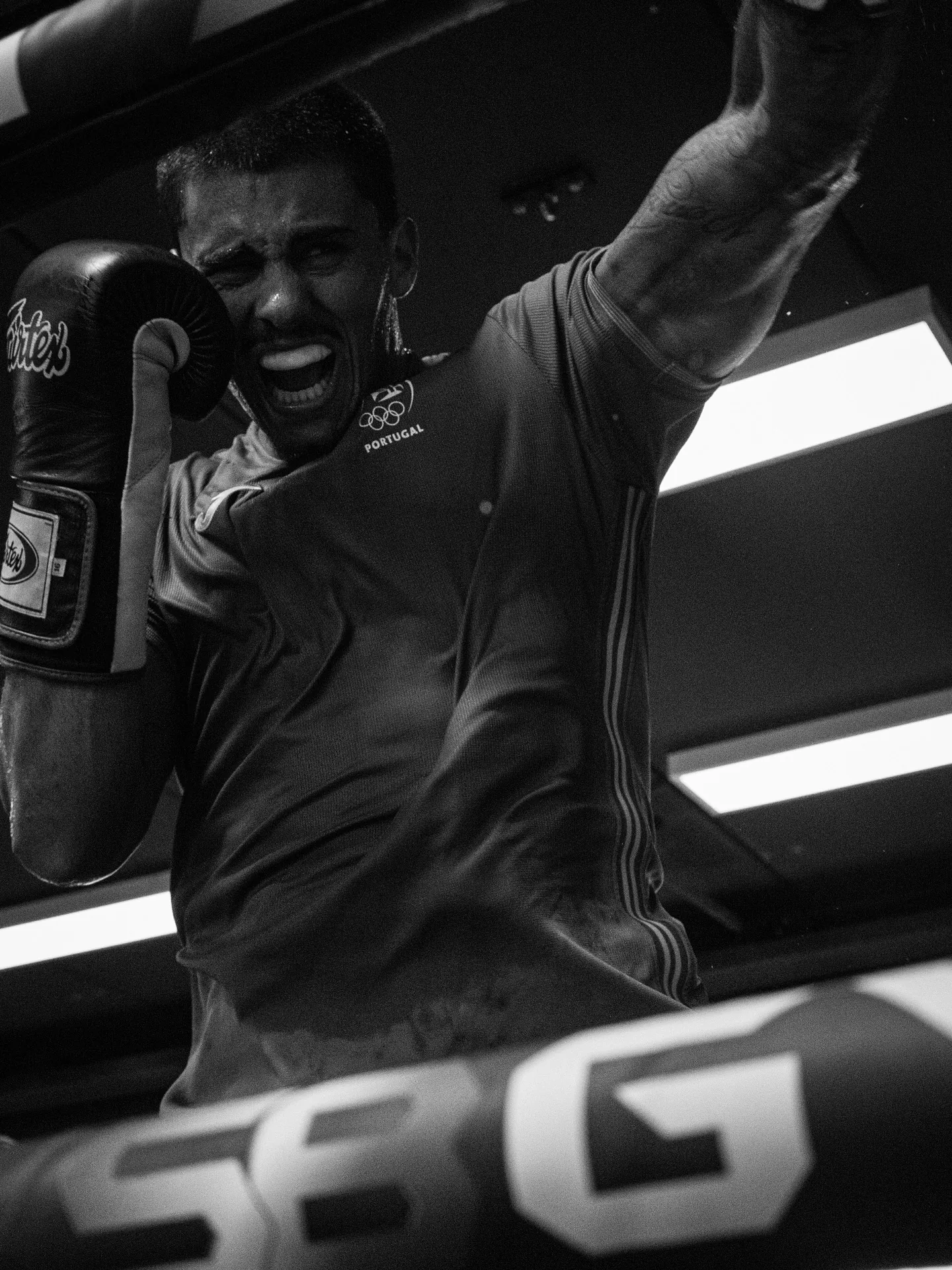 Kickbokser Santos schreeuwt het uit in de ring, zwart-wit
